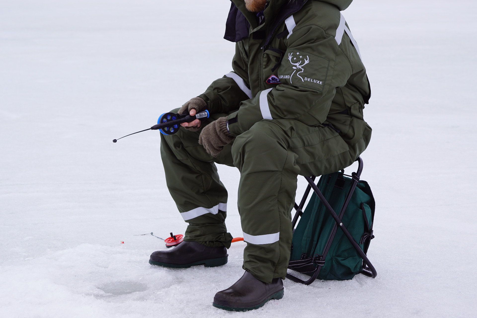 Ice fishing on frozen lake Vanttausjärvi Lapland Deluxe